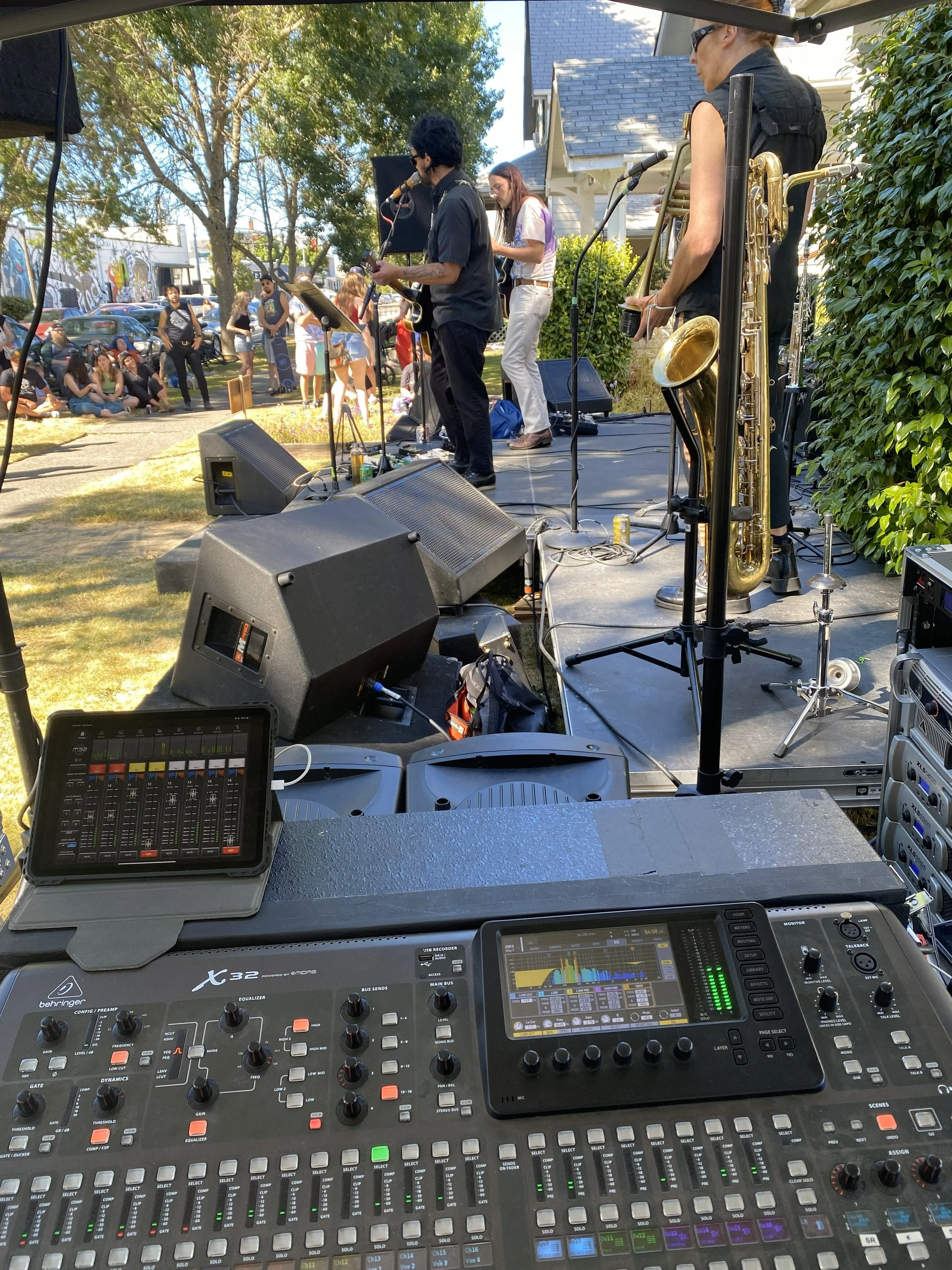 Side view of a stage at Tacoma Porch Fest, from the perspective of the audio engineer behind the mixing board.