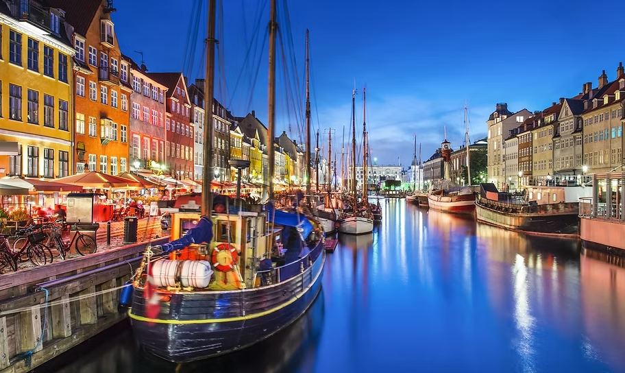 Rues colorées avec des bâtiments le long d'un quai de port, bateaux amarrés, ambiance nocturne