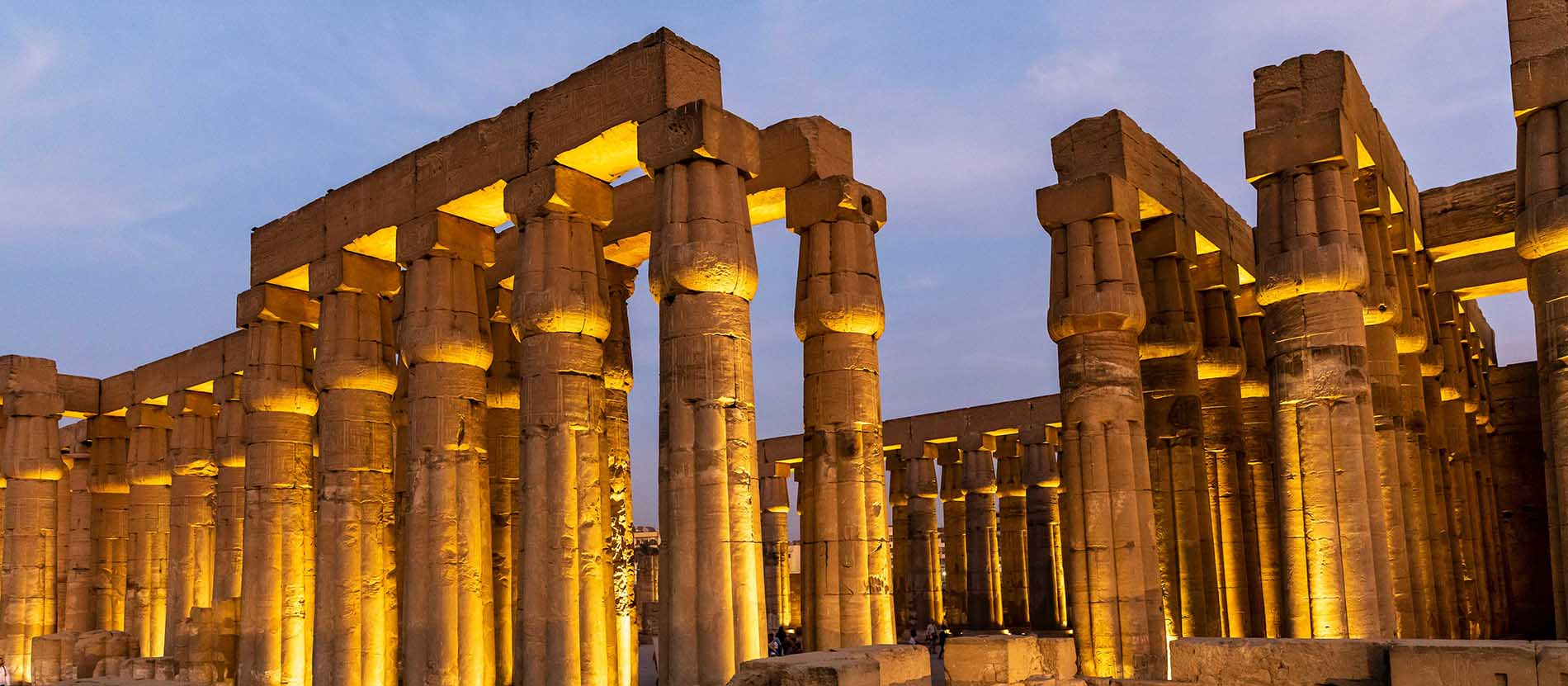 Ruines du temple grec ancien illuminées la nuit, avec de nombreuses colonnes en pierre