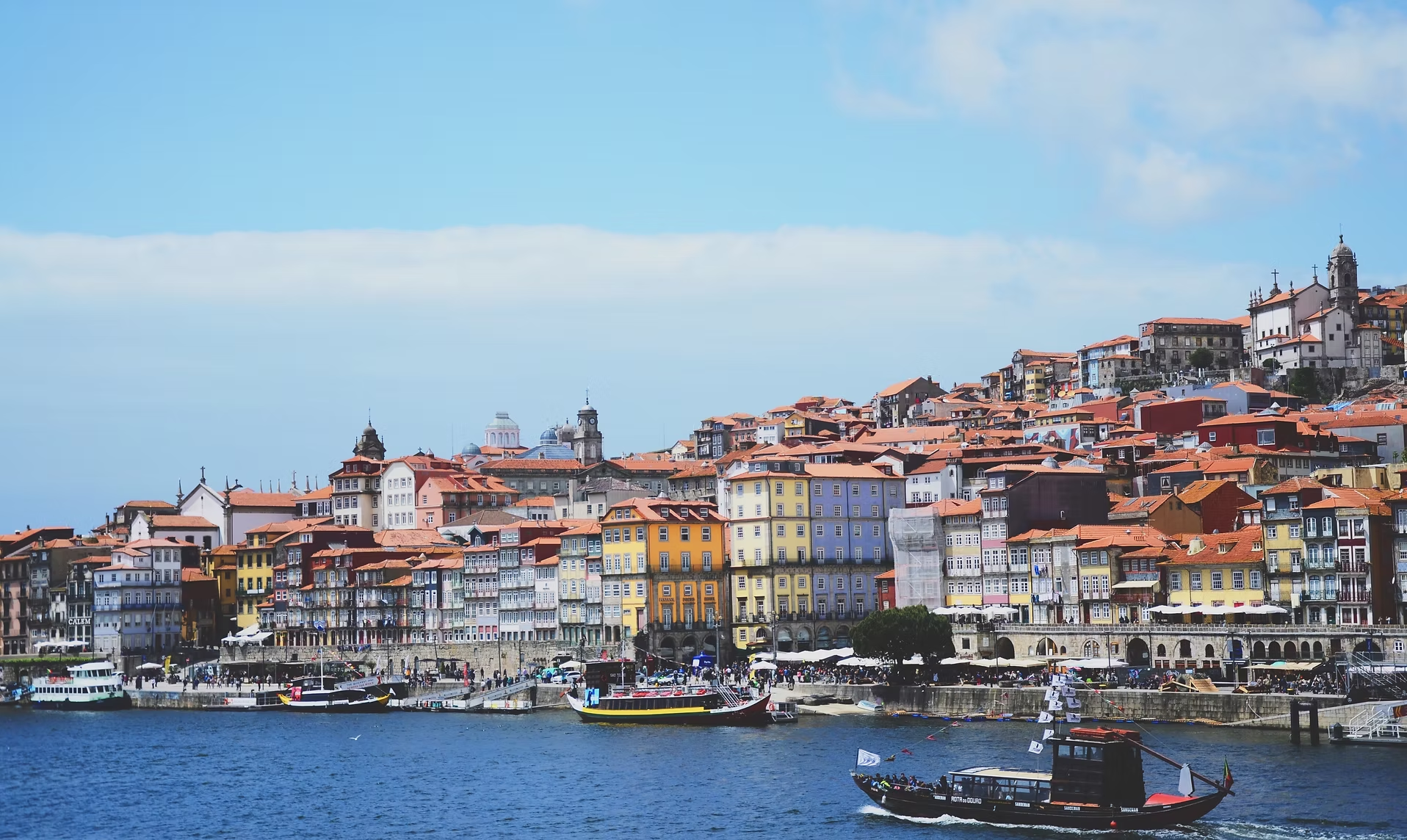 Vieux port de Porto avec des bateaux Traditionnels sur la rivière et bâtiments colorés sur la colline
