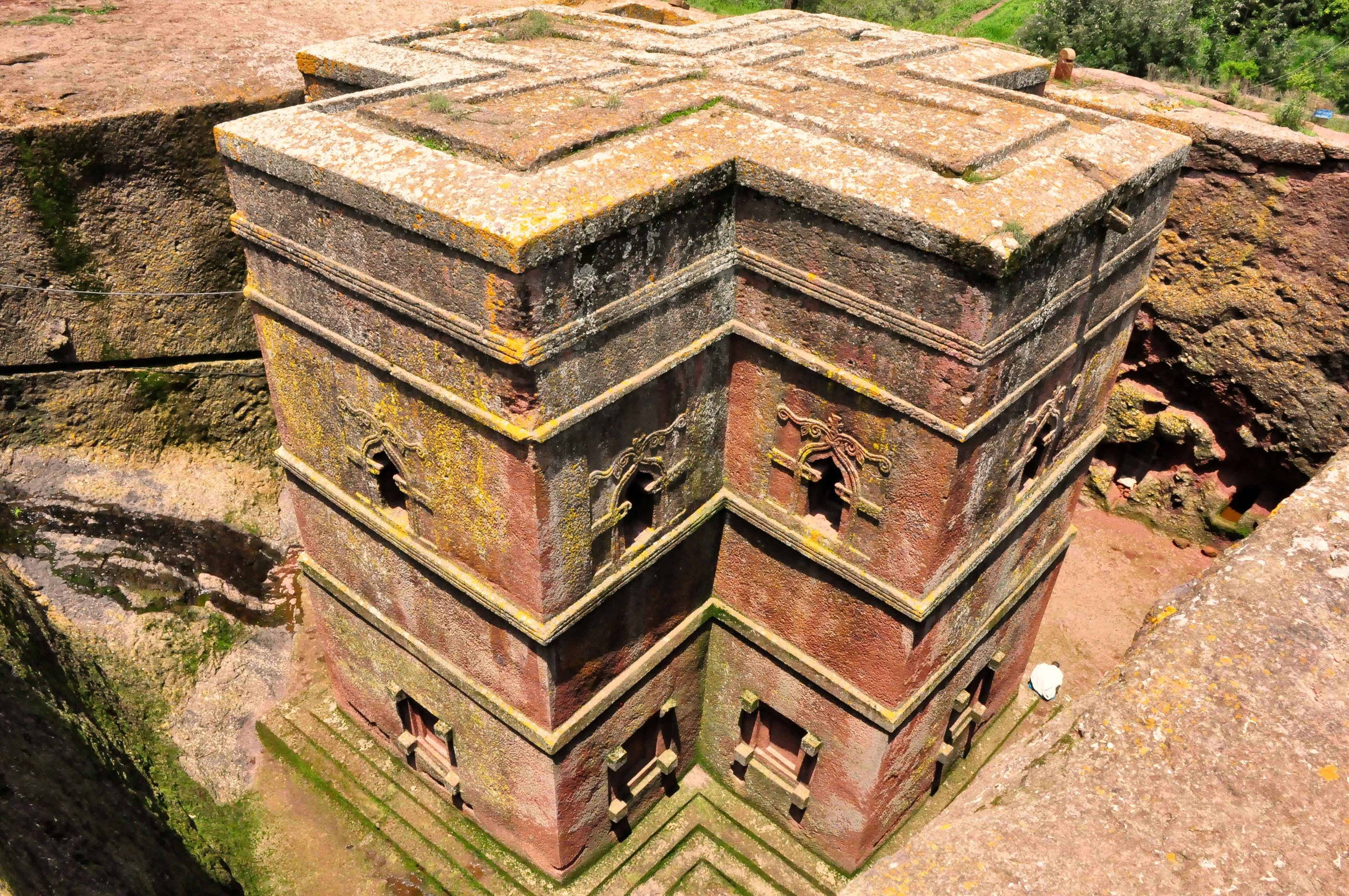 Une pyramide de temples en pierre richement décorés, recouverte de mousse et de lichens, vue d'en haut.