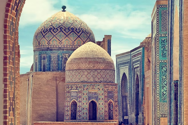 Des mosquées avec des dômes colorés et des murs richement décorés en céramique, dans un site historique en architecture islamique.