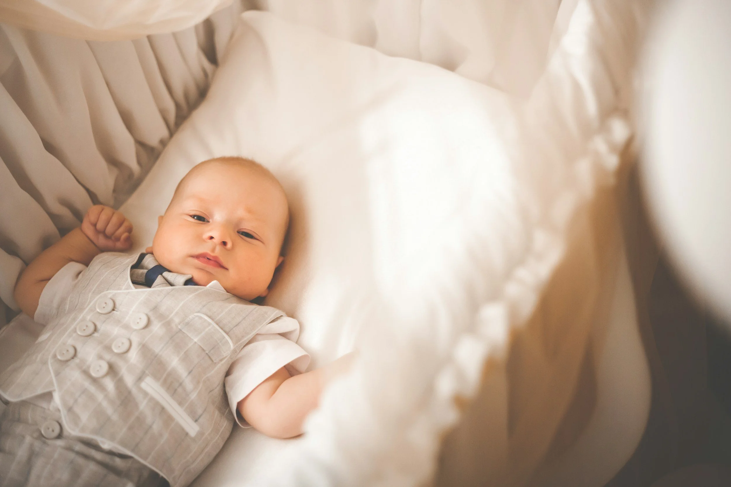 Baby im Bett, das direkt in die Kamera blickt