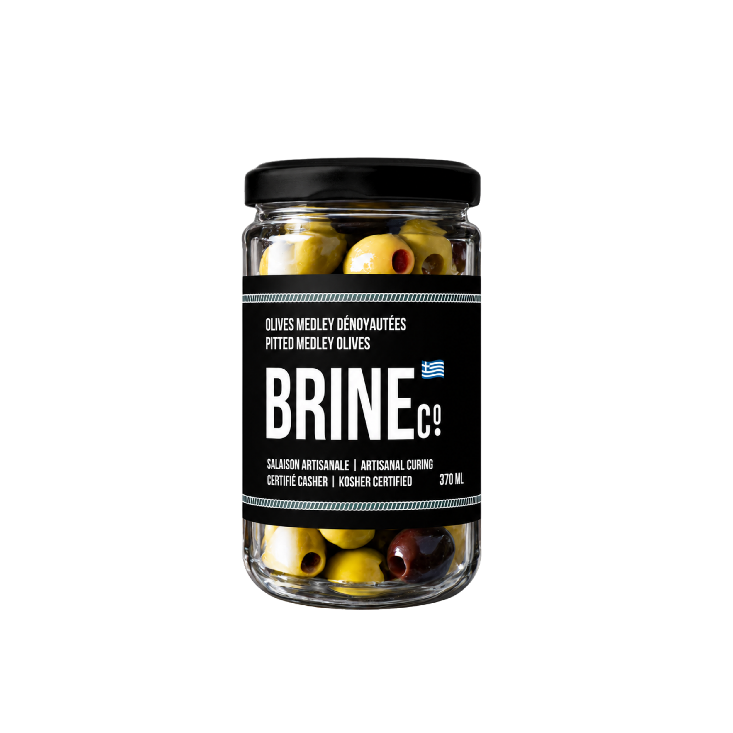 A glass jar of Greek pitted medley olives with a black lid, featuring green and purple olives inside.
