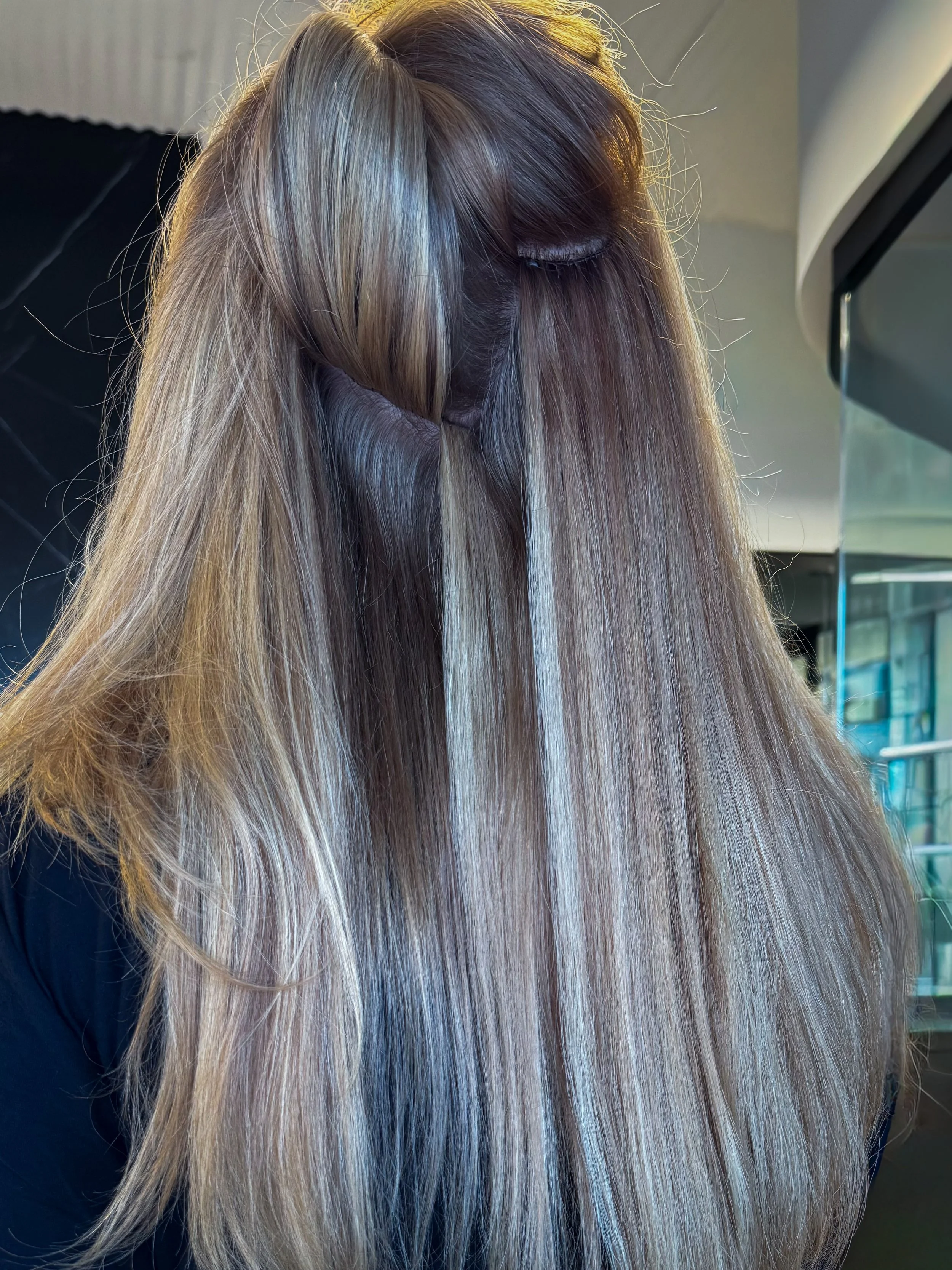 Invisible bead extensions seamlessly installed on blonde hair for longer, fuller hair.