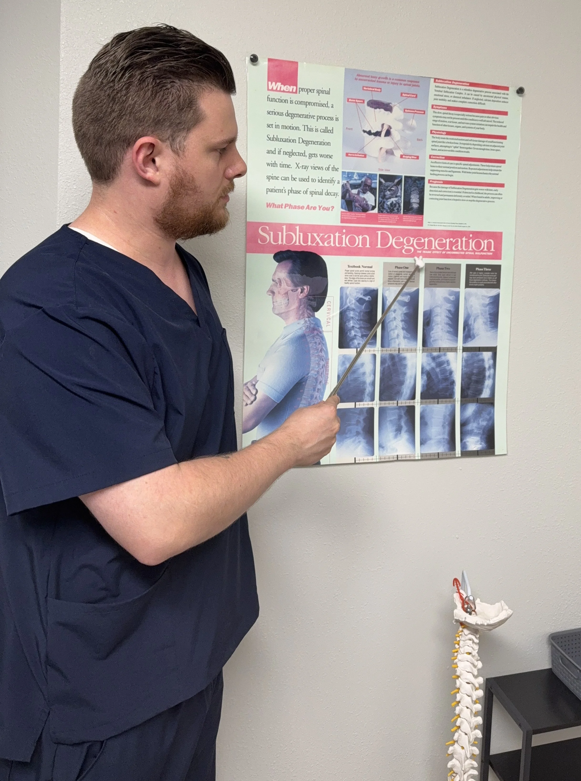 Dr. Cross explains spine anatomy on a poster