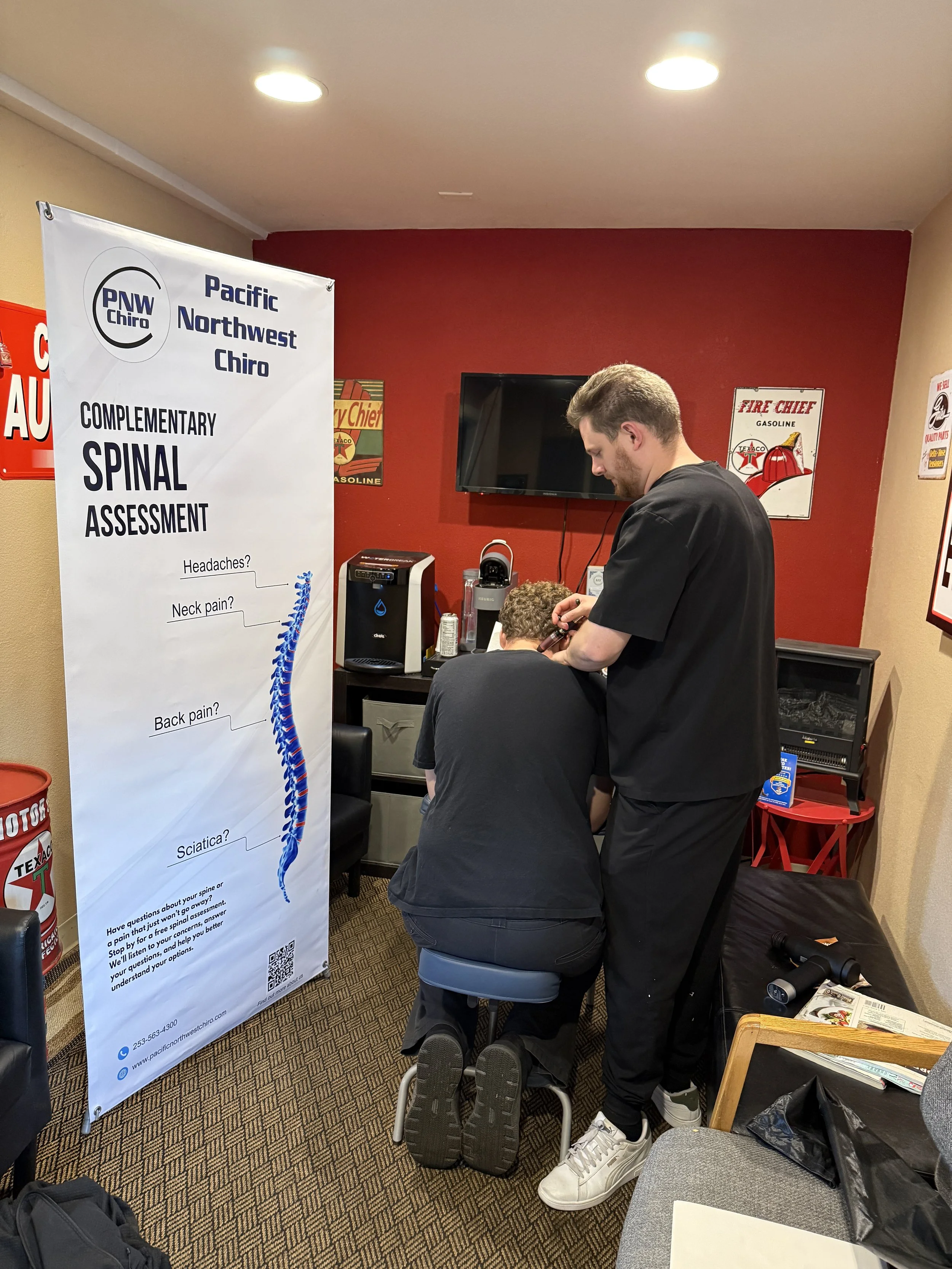 Dr. Huxley Cross providing an onsite spinal assessment during a Pacific Northwest Chiro workplace event
