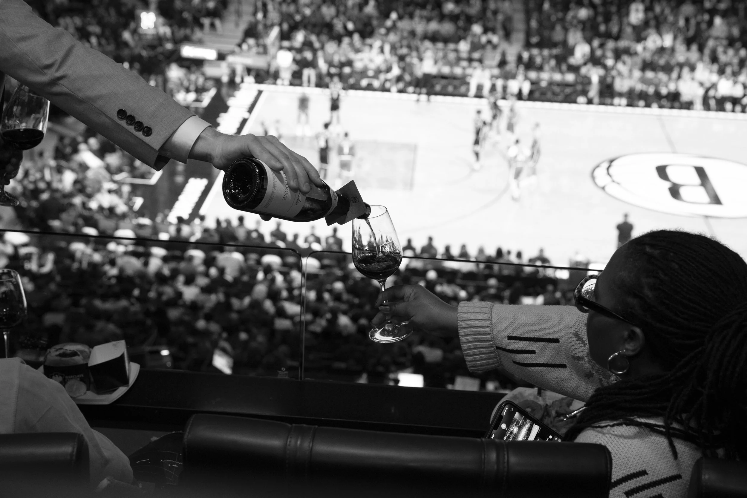 Wine being poured courtside during a basketball game.