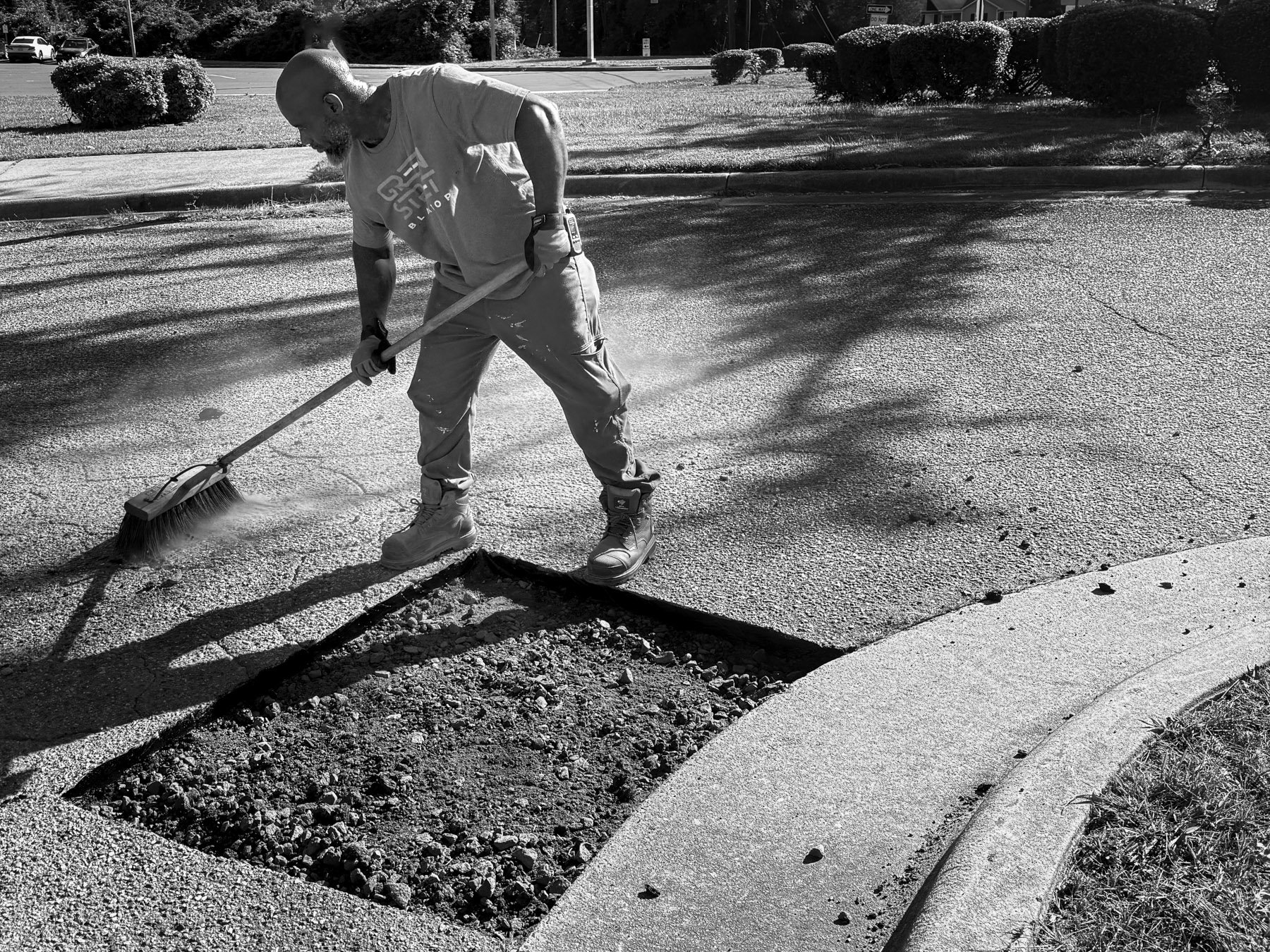 Green Street Blacktop crew clearing debris before asphalt base repair, Durham NC