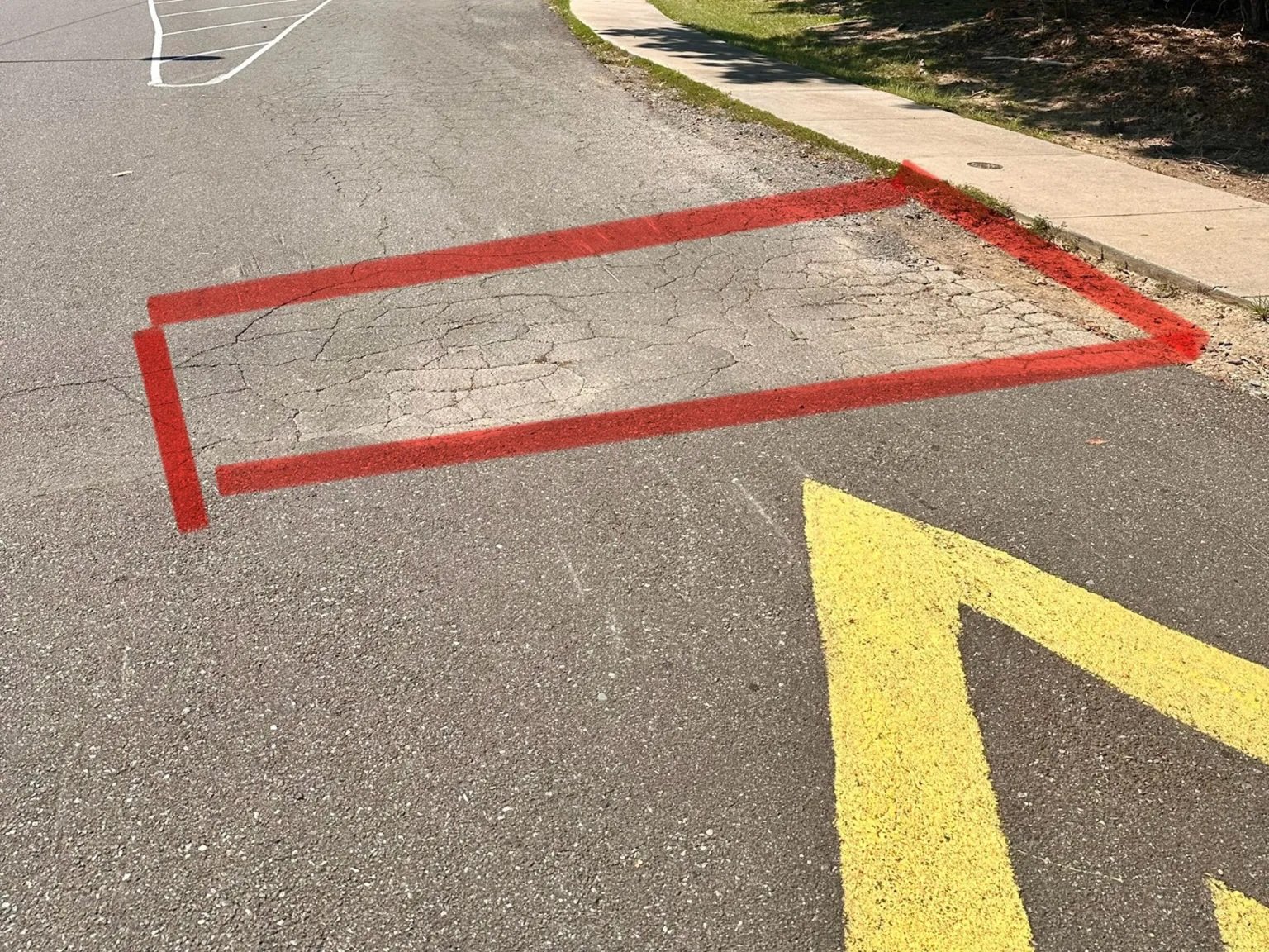 Asphalt outlined for pothole repair near a speed bump, Durham NC
