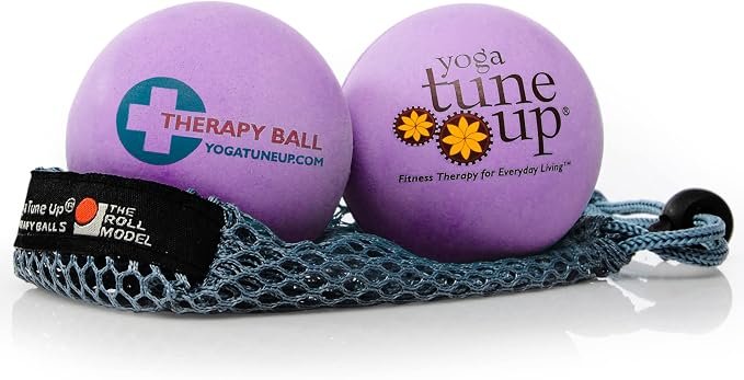 Two purple therapy balls on a blue mesh carrying case with a black strap, one labeled 'Therapy Ball' and the other 'Yoga Tune Up'.