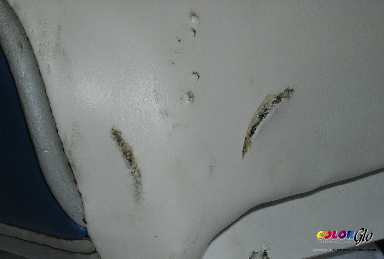 Close-up of a white surface with peeling paint and black mold spots.