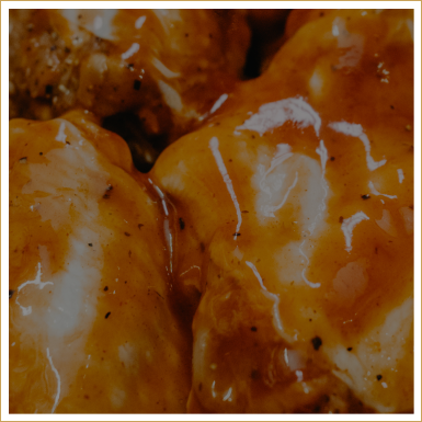 Close-up of glazed chicken pieces with sauce.