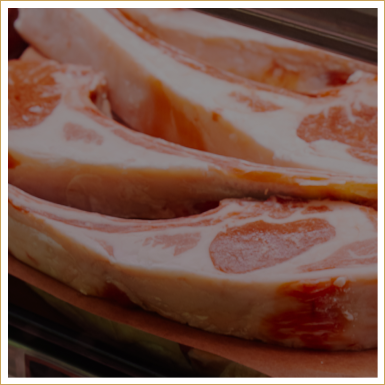 Raw pork chops on a tray.