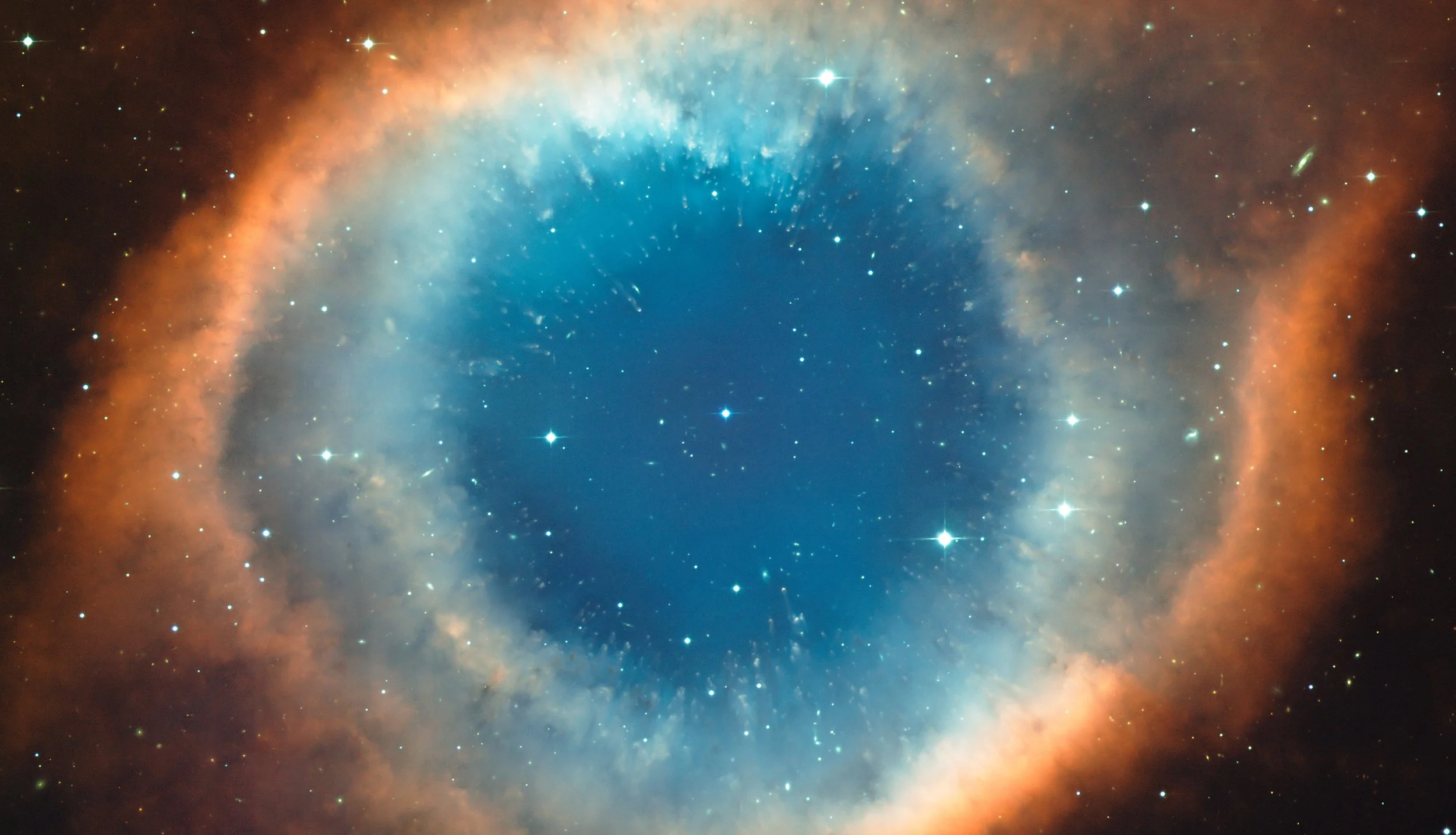 An image of a colorful nebula in outer space with stars scattered throughout.