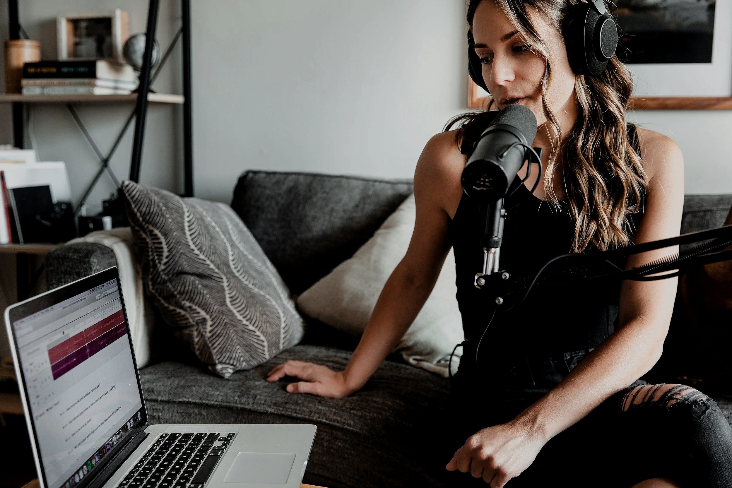 Kvinna spelar in podcast med dynamisk mikrofon och hörlurar – professionell podcast- och ljudboksinspelning i Uppsala hos Mixrummet