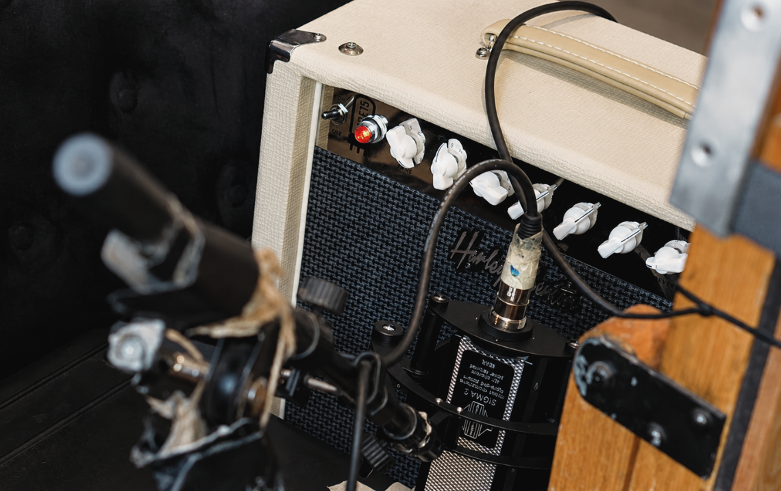 Närbild på mikrofonuppsättning framför gitarrförstärkare under inspelning hos Mixrummet i Uppsala – professionell gitarrinspelning med bandmikrofon och analog utrustning