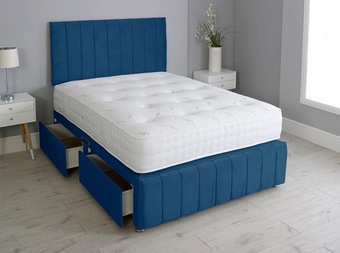 A bedroom with a blue upholstered bed frame with storage drawers, and a strong comfy premium mattress all whilst being affordable.