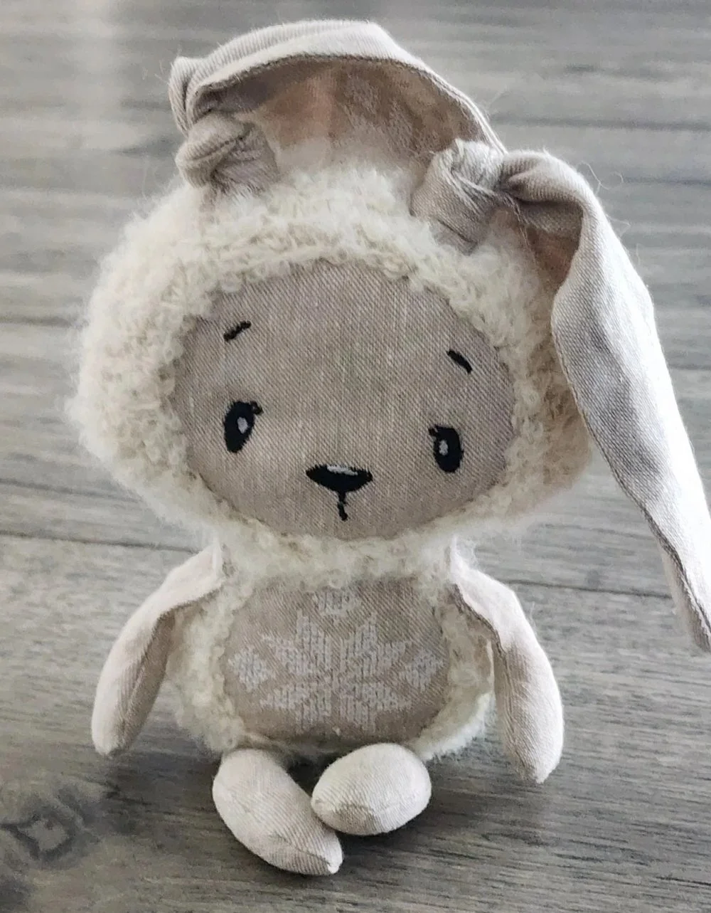 Finished Protective Bunny with crocheted body, linen details, and embroidered face and symbol
