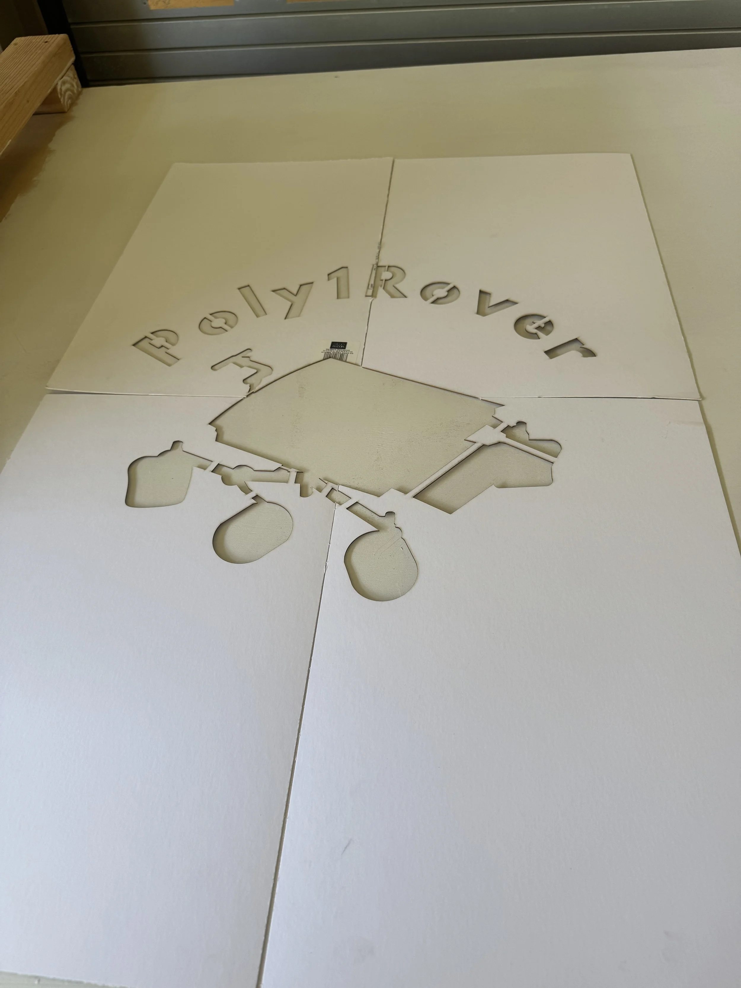 Laser cut stencil of Poly1Rover logo