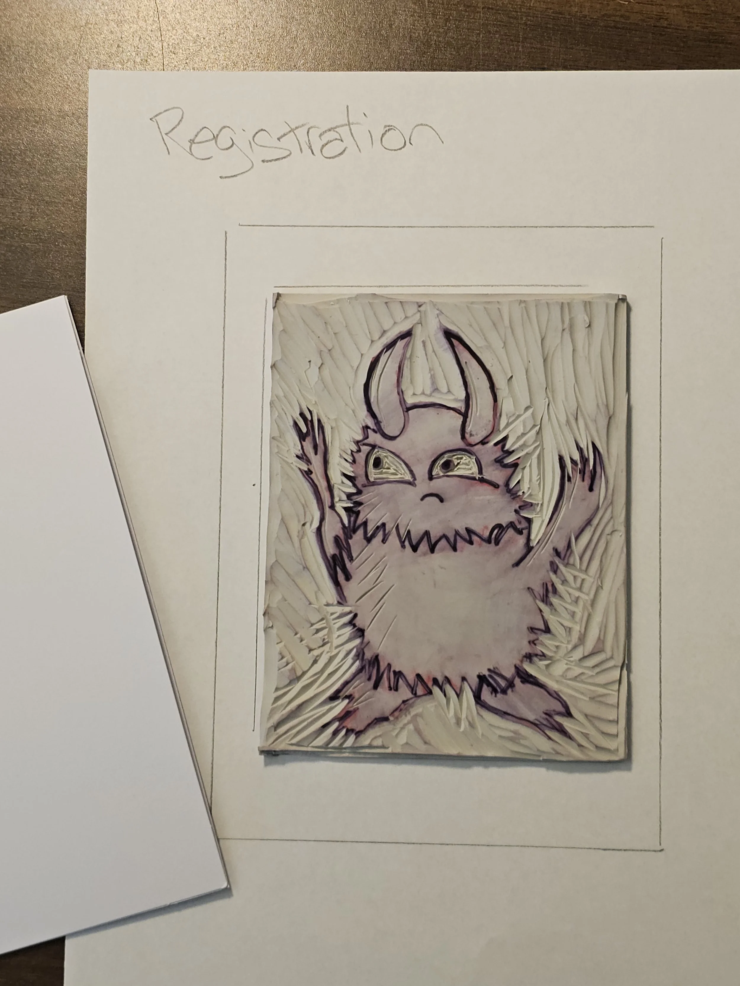 A piece of paper with the word 'Registration' written at the top, and a drawing of a feline or fox face with pointed ears and a mischievous expression, created with colored pencils or markers on a textured background.