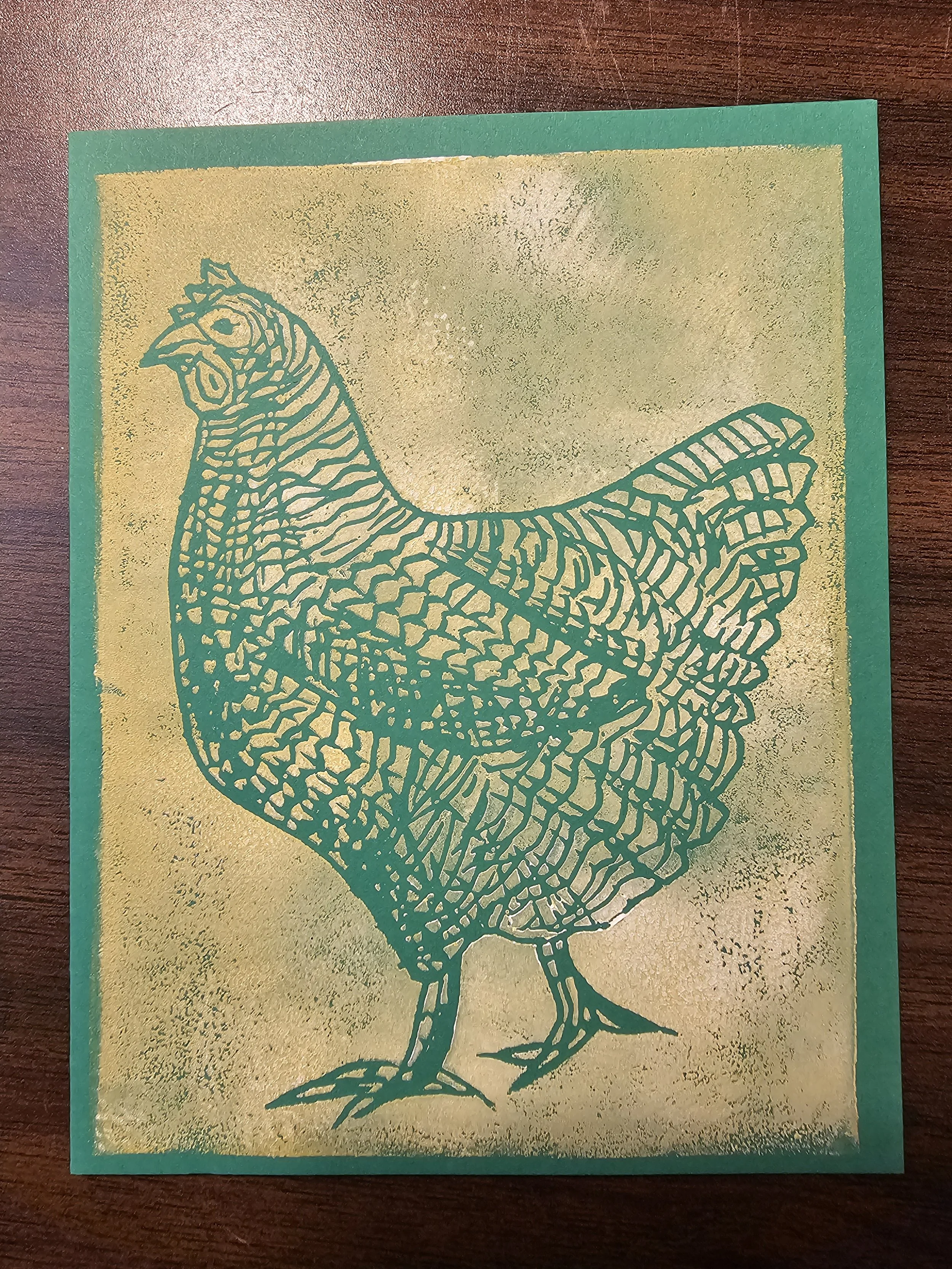 Green greeting card with a gold background featuring a simple outline drawing of a chicken or rooster.