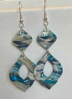 Pair of marbled acrylic dangle earrings with silver hooks, featuring geometric shapes with a blue and white swirl pattern.