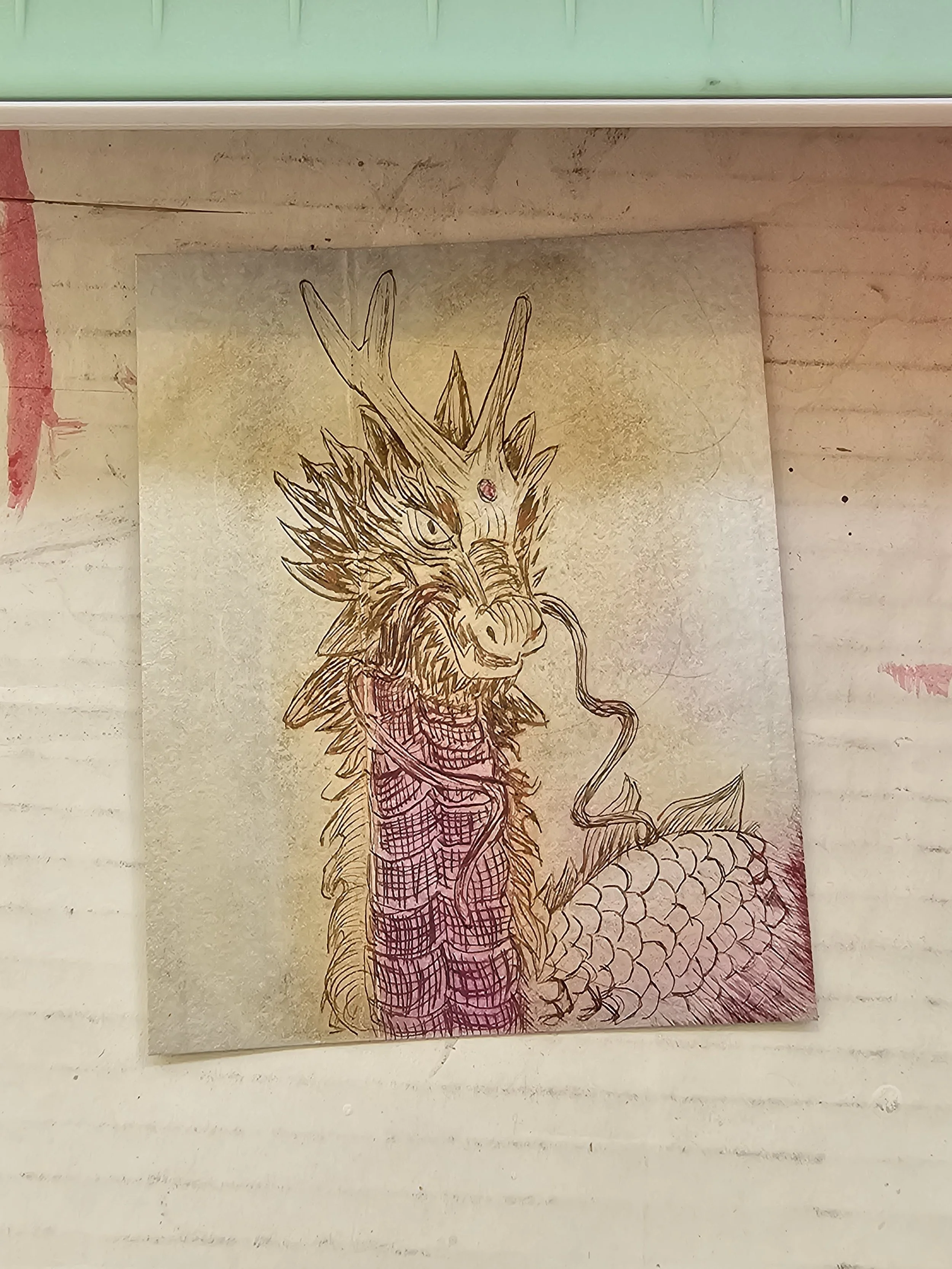 Line drawing of a mythological dragon with antlers, scales, and fierce expression on parchment paper.