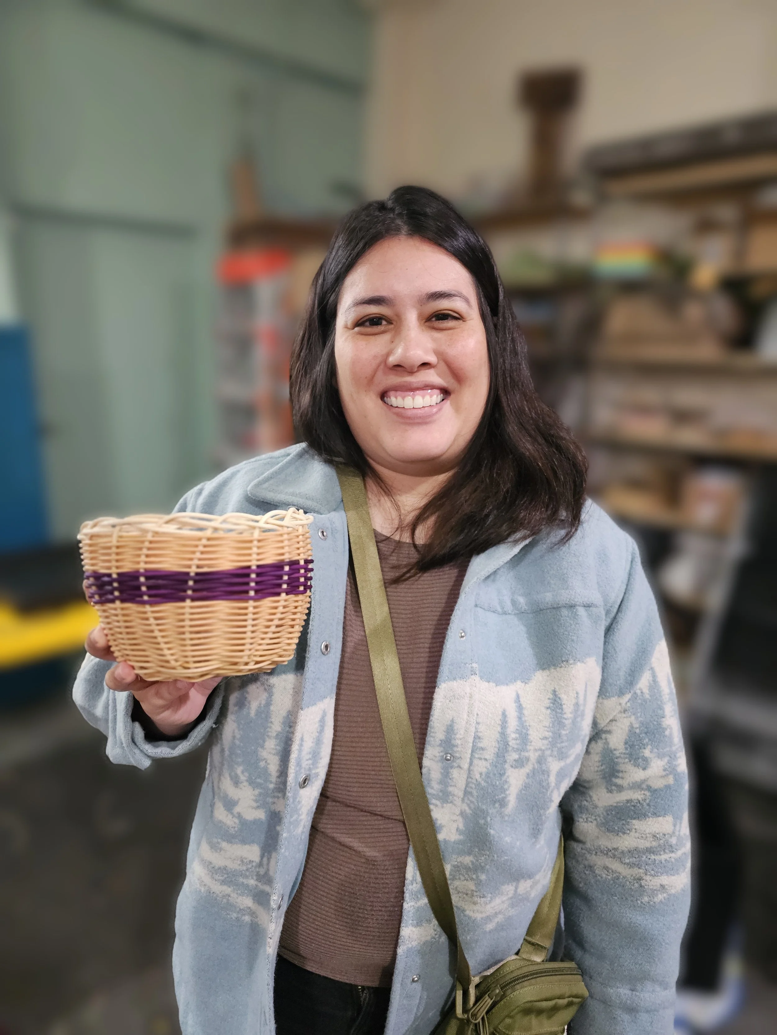 Smiling woman holding a woven basket in a grocery store