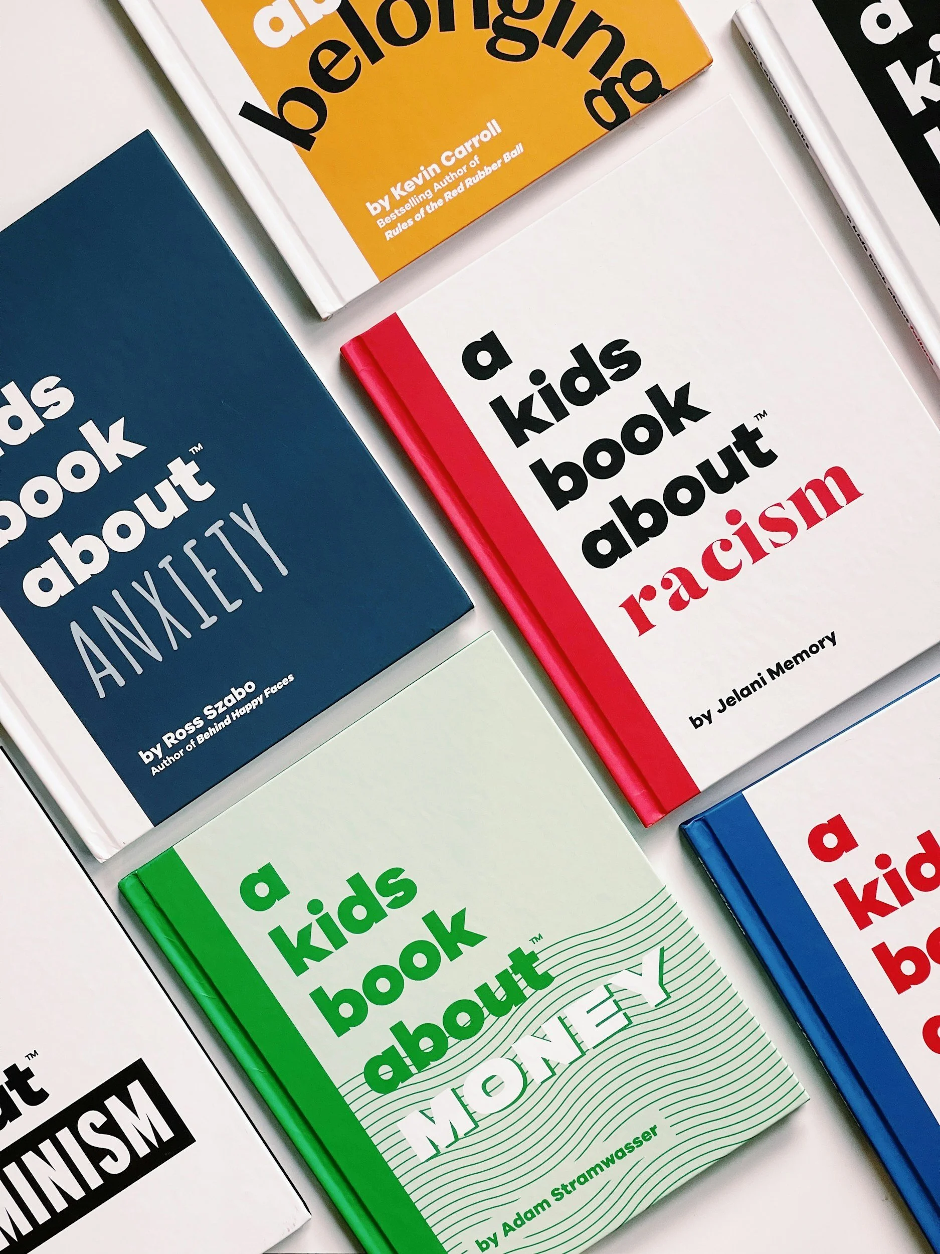 Collection of children's books titled 'a kids book about' with different colors including green, white, red, blue, and yellow, arranged on a white surface.