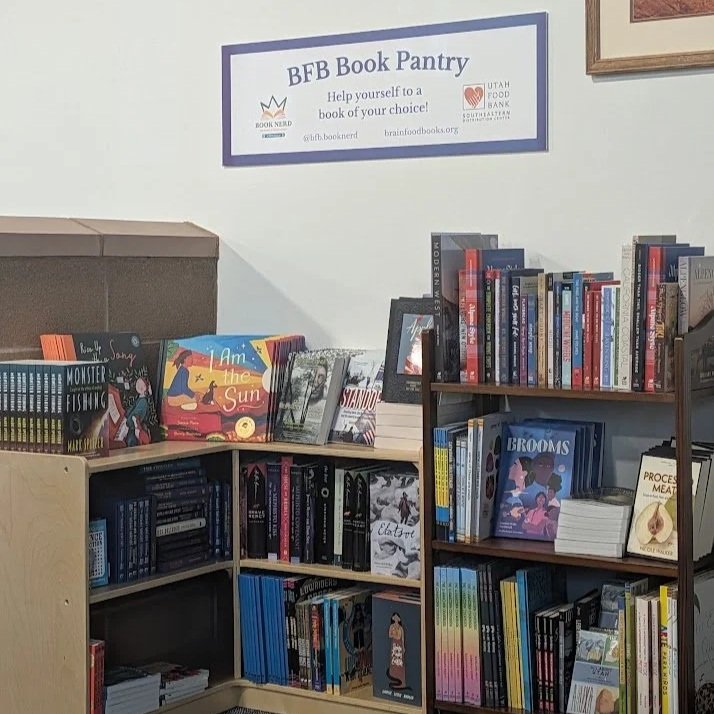 Bookshelves filled with children's books in a library, part of a book pantry project for free community book sharing.