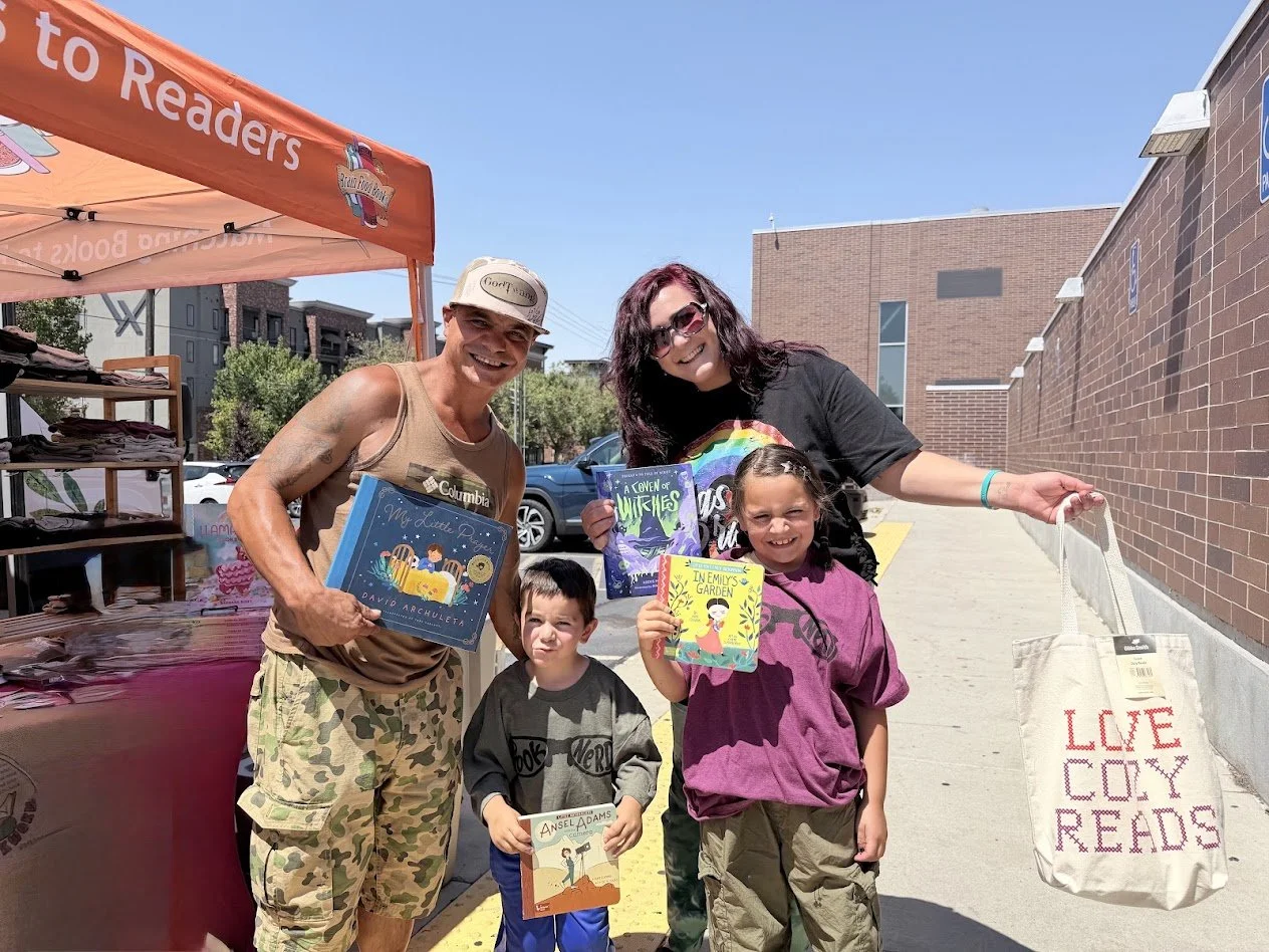 family smiling holding books at bfb event