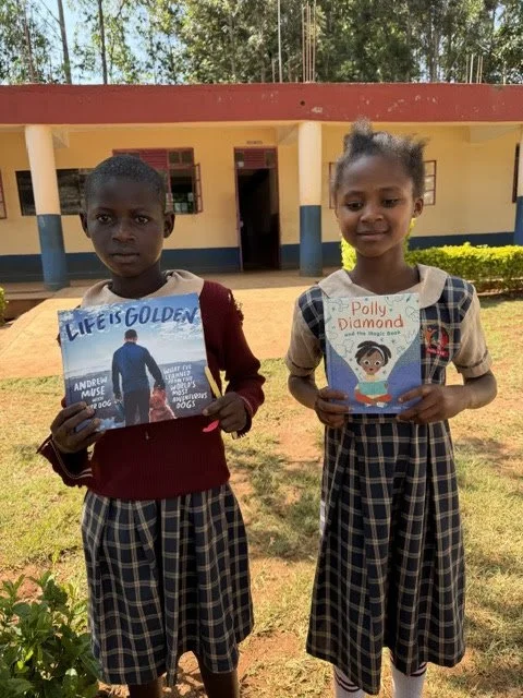 Two Children holding books they chose from BFB's initatives in Kenya
