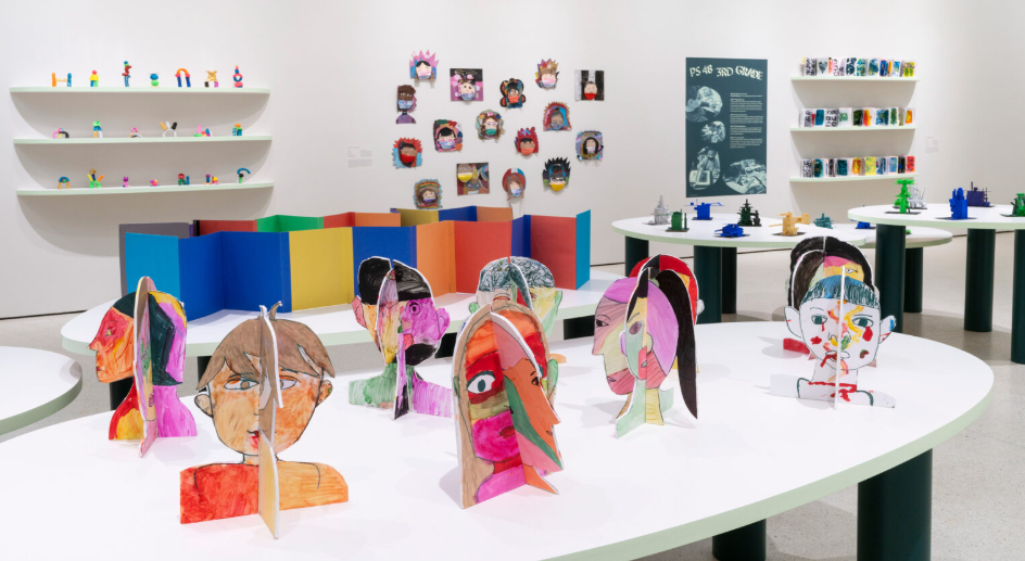 Colorful spiral-bound art sculptures of human faces on display in an art gallery.
