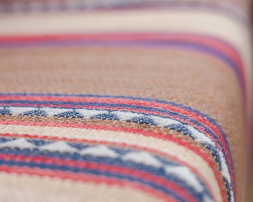 Close-up of a colorful woven textile, featuring red, white, and blue stripes.