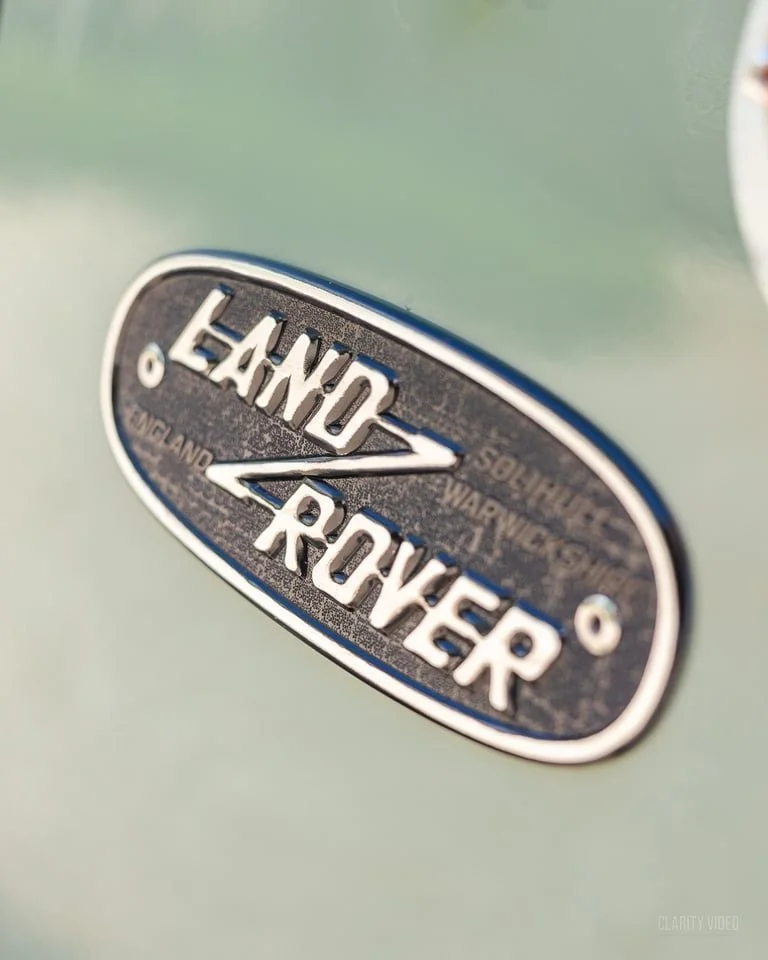 Close-up of a Land Rover badge on a green vehicle.