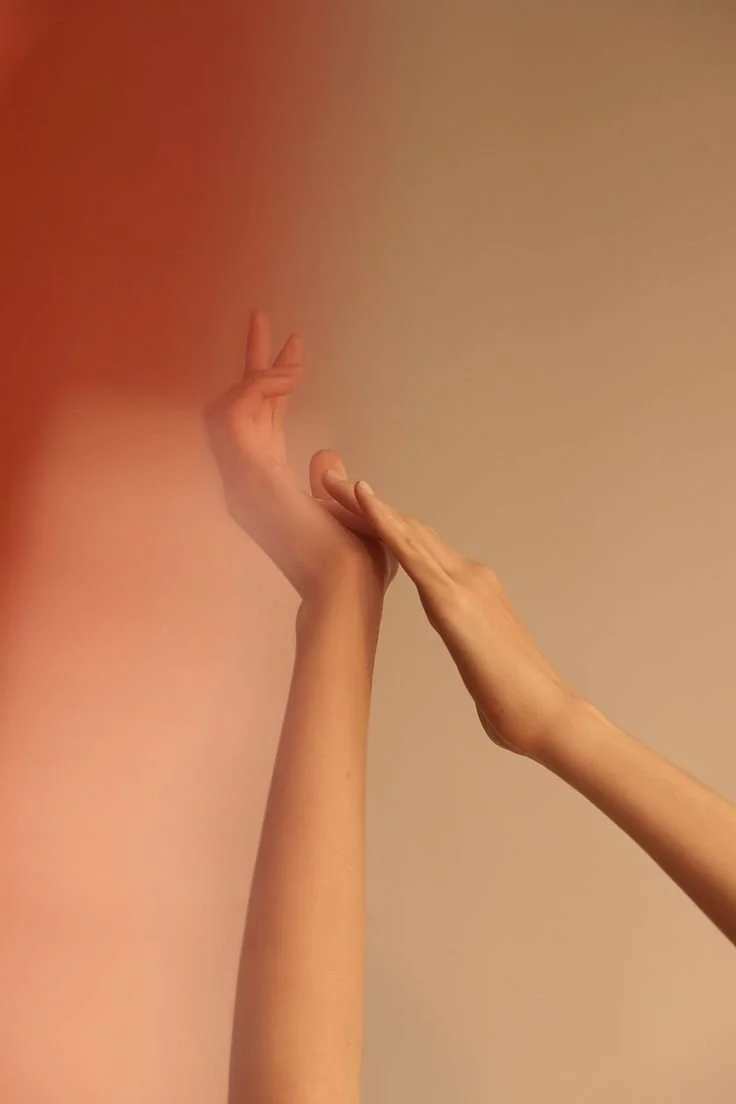 Two hands reaching towards each other, one with fingers extended and the other with the palm open, against a neutral background.