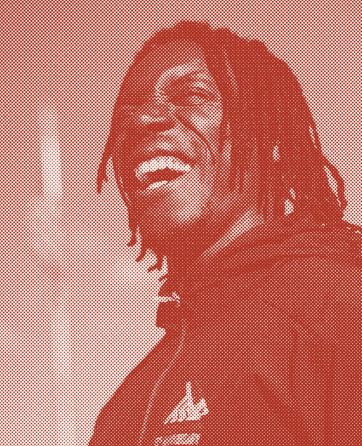 A man with dreadlocks, smiling wearing a jacket.