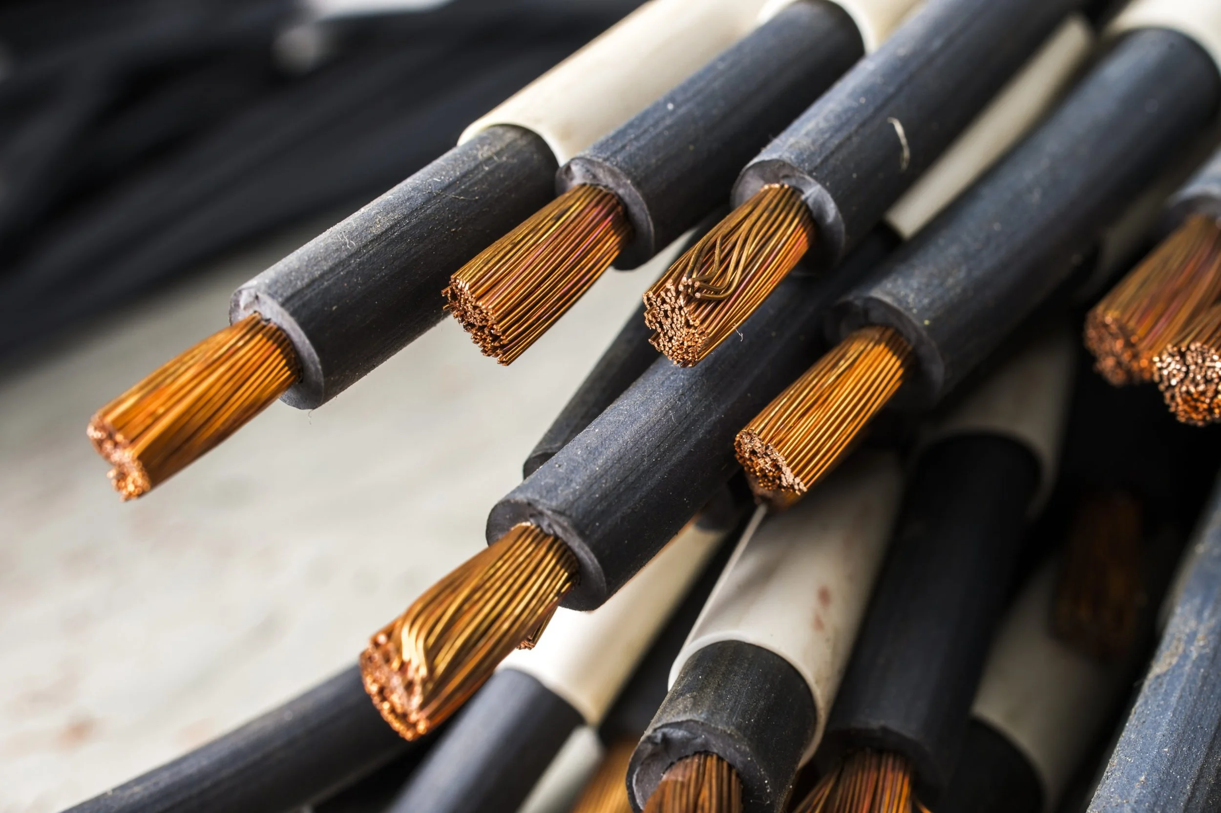 Close-up of several electrical cables, some with exposed copper wires