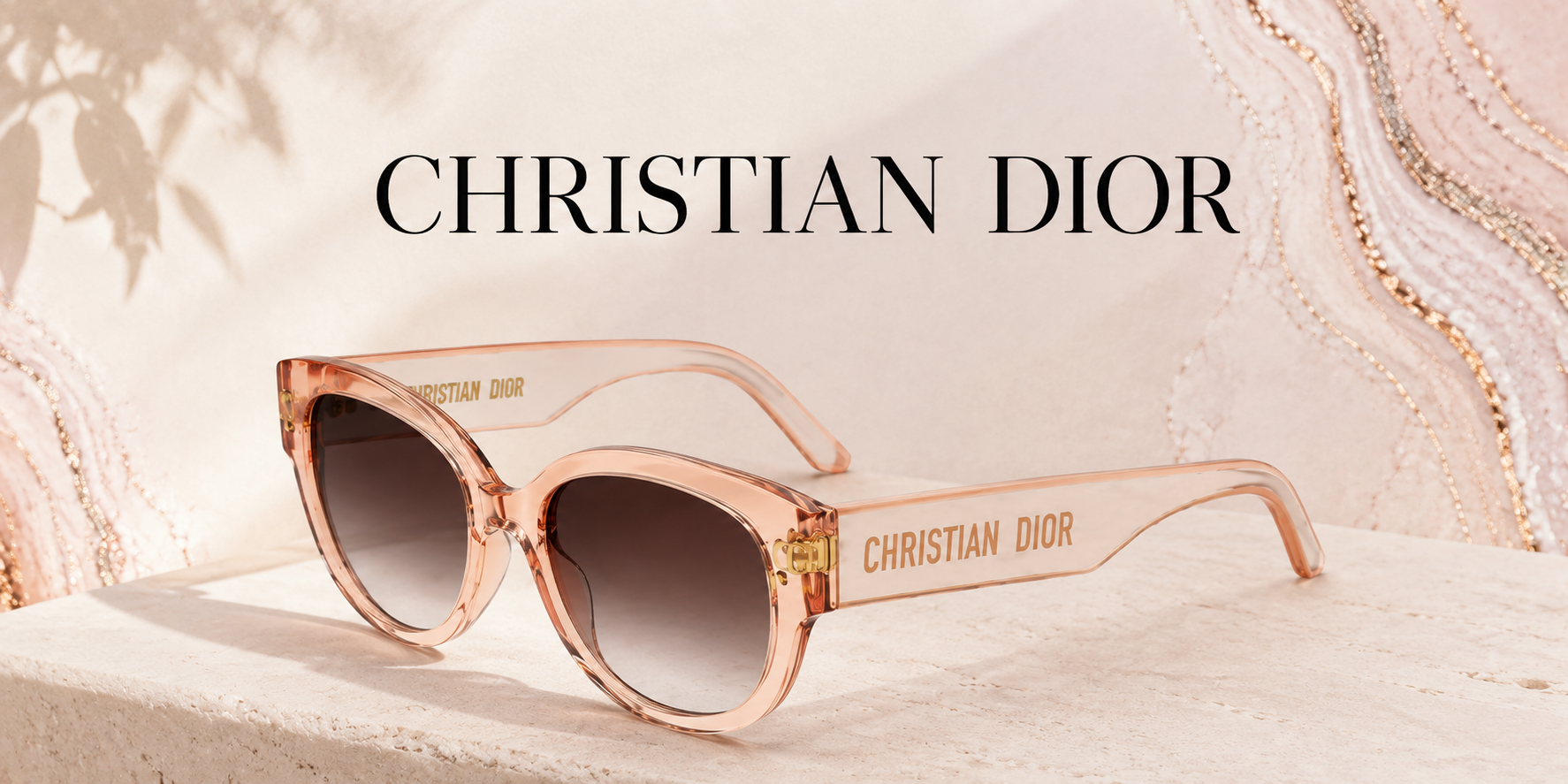 Pink Christian Dior sunglasses with dark lenses, placed on a light-colored textured surface, with the brand name on the temples and a soft, elegant background featuring pink and beige marble patterns and shadows of leaves.