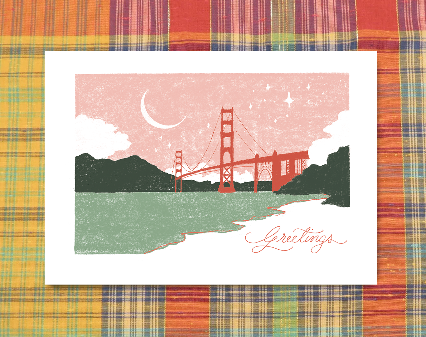 A greeting card with a stylized illustration of the Golden Gate Bridge at sunset, with a crescent moon and stars in the sky, mountains in the background, and water in the foreground. The word 'Greetings' is written in elegant script at the bottom rig