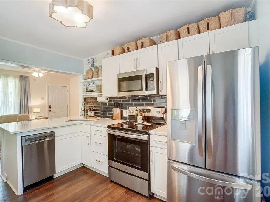 Gourmet kitchen with white cabinets and stainless appliances in a Fort Mill SC home for sale with Penny Sheppard