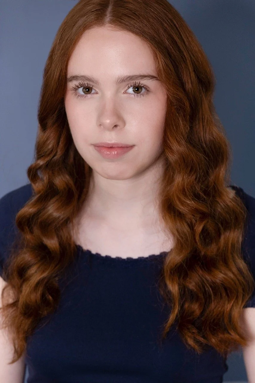 Kassia in a blue shirt with a serious expression