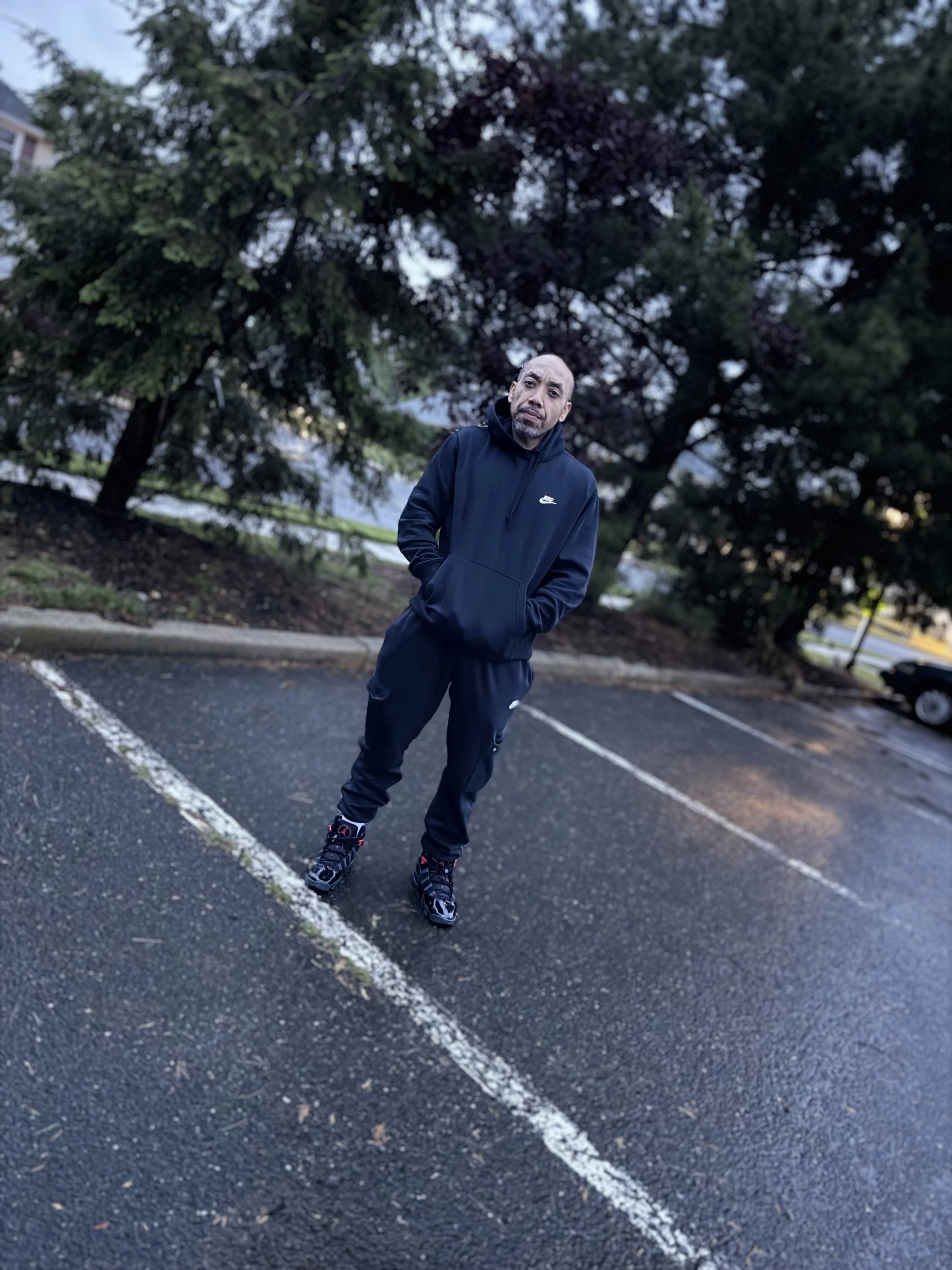 Eddie P standing outdoors in a black tracksuit