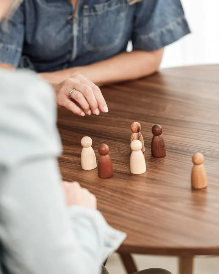 Persona realizando una constelación de su sistema familiar con figuras