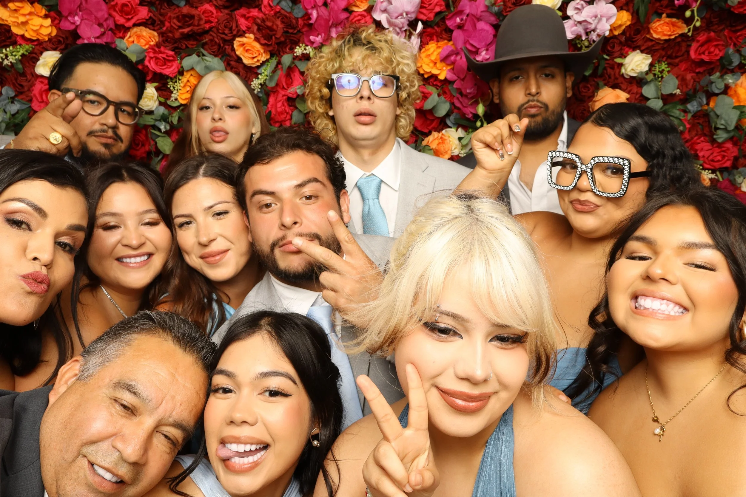 Group of diverse people taking a selfie in front of a floral background.