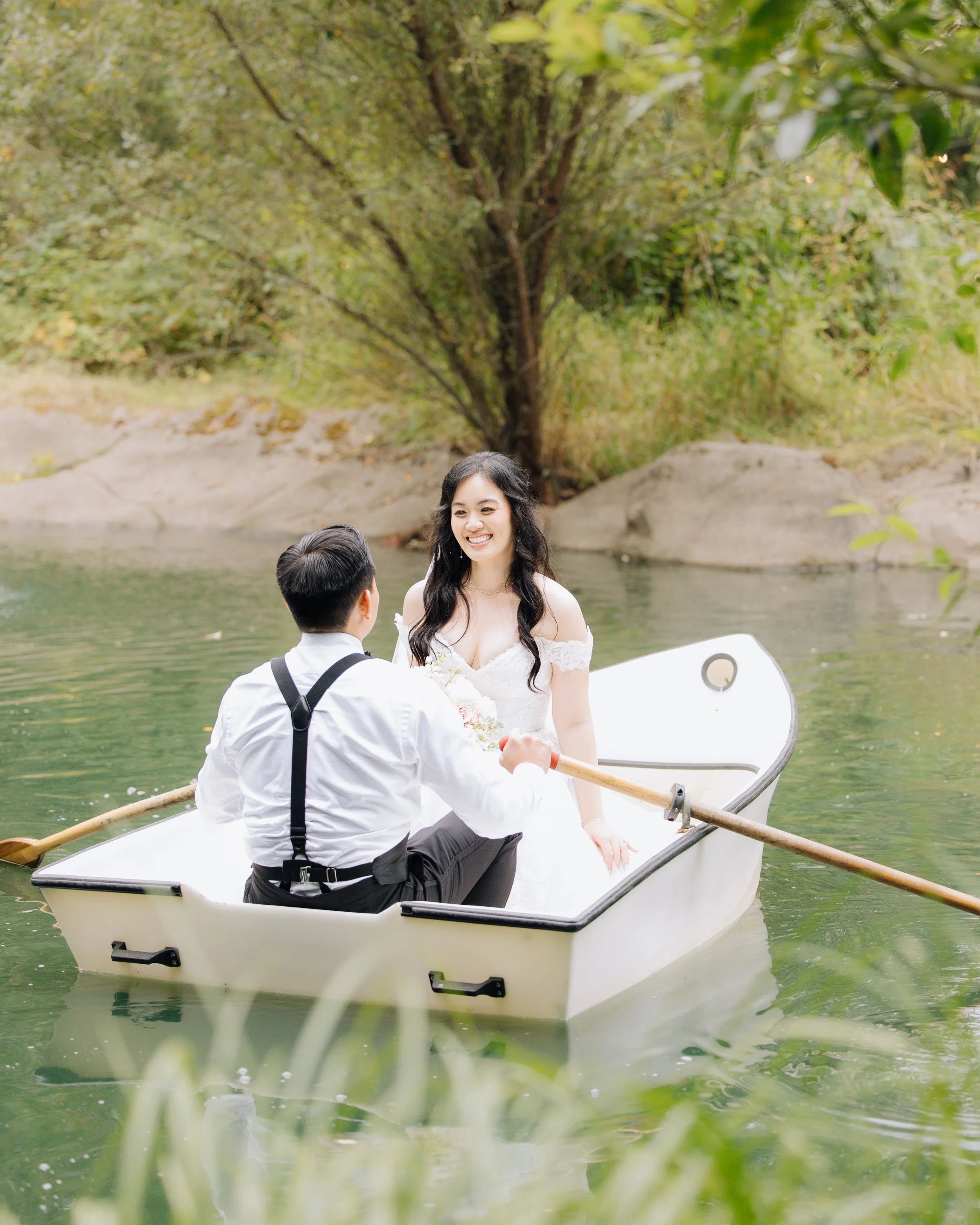 Bride and groom sharing a quiet moment together in a rowboat during their wedding day.