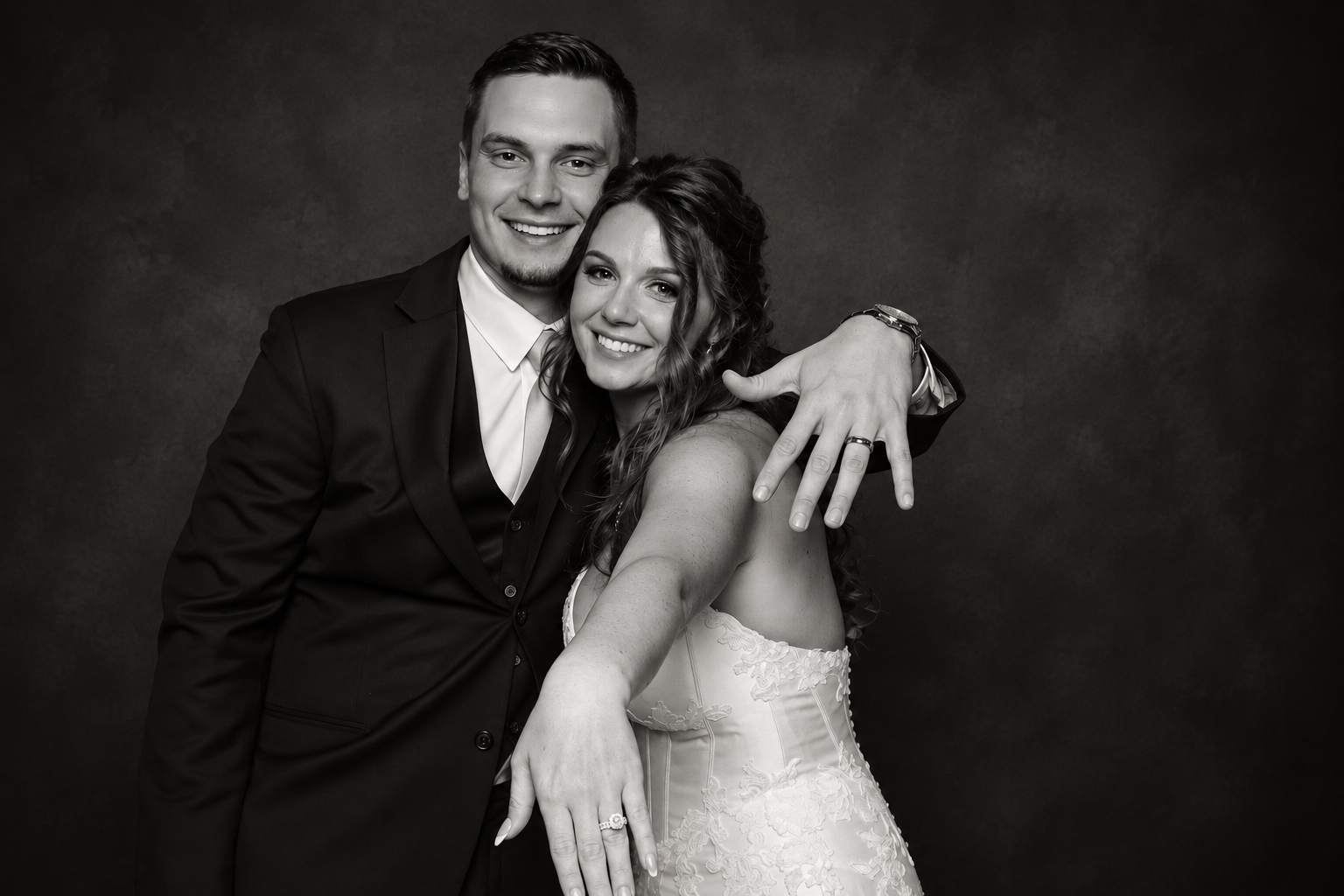 Bride and groom posing for a black-and-white studio portrait on their wedding day.