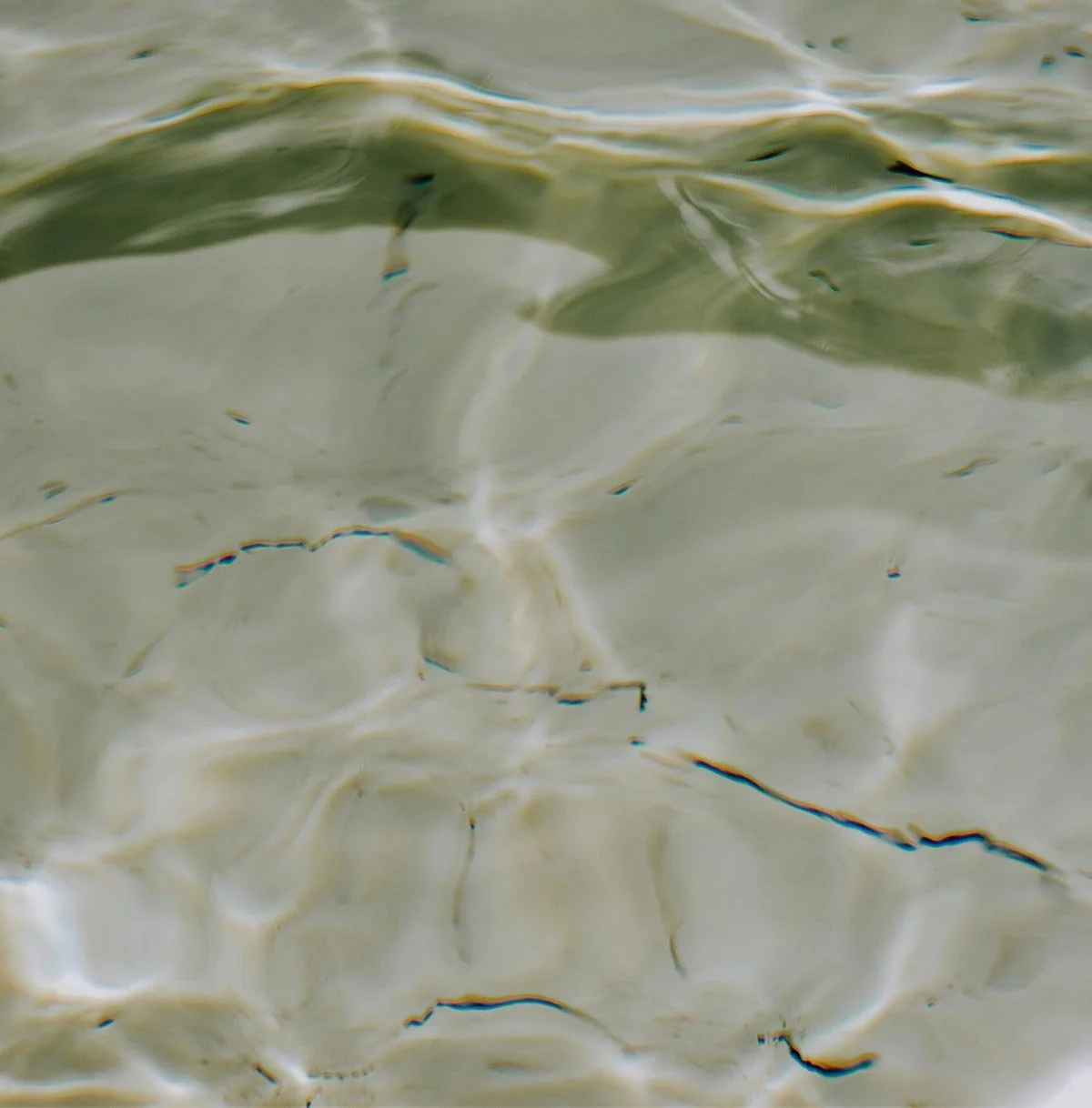 Close-up of water surface with ripples and reflections.