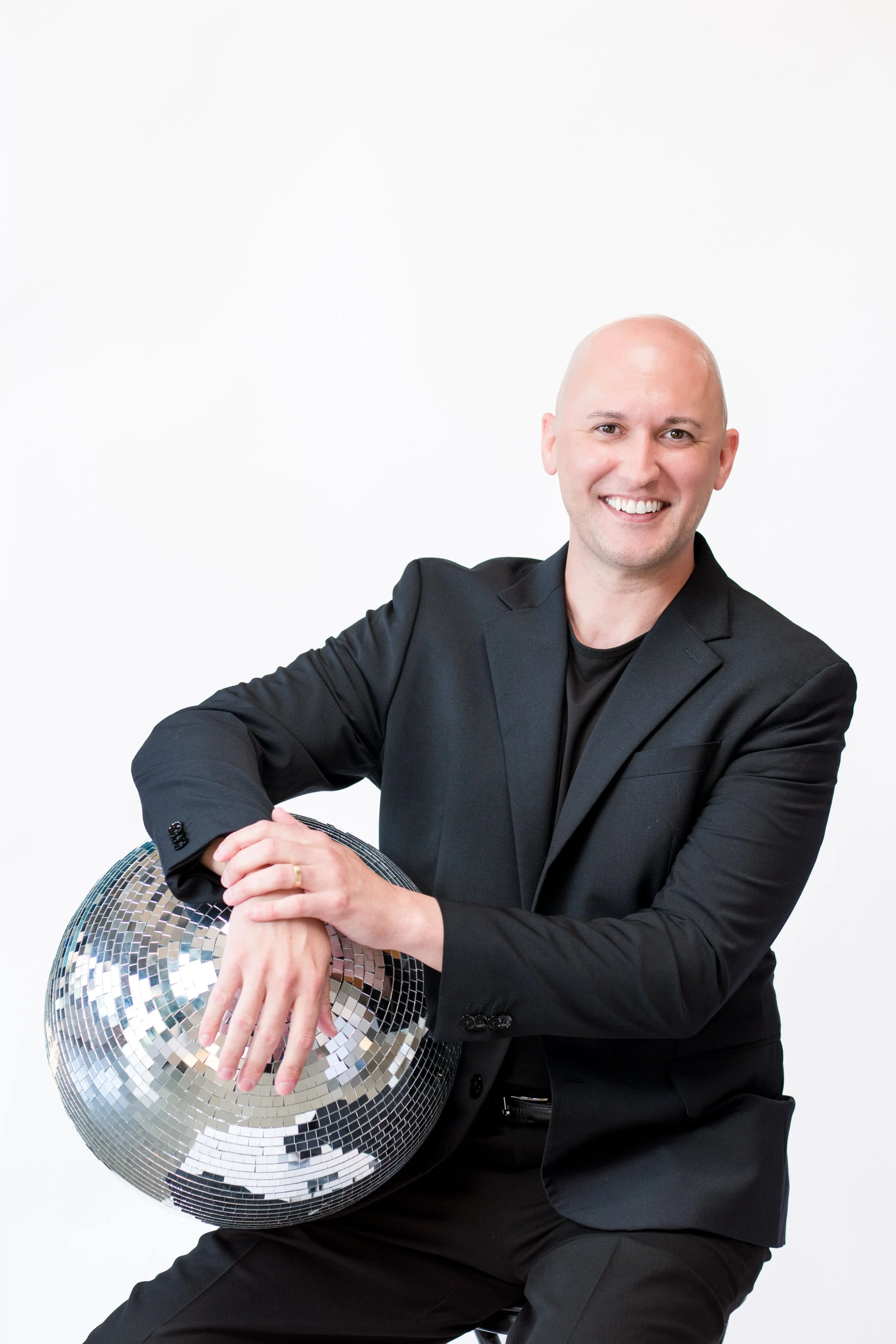 guy in black suit holding a disco ball
